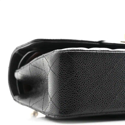 Chanel small double flap bag bottom view, black pebbled leather texture and curved edge