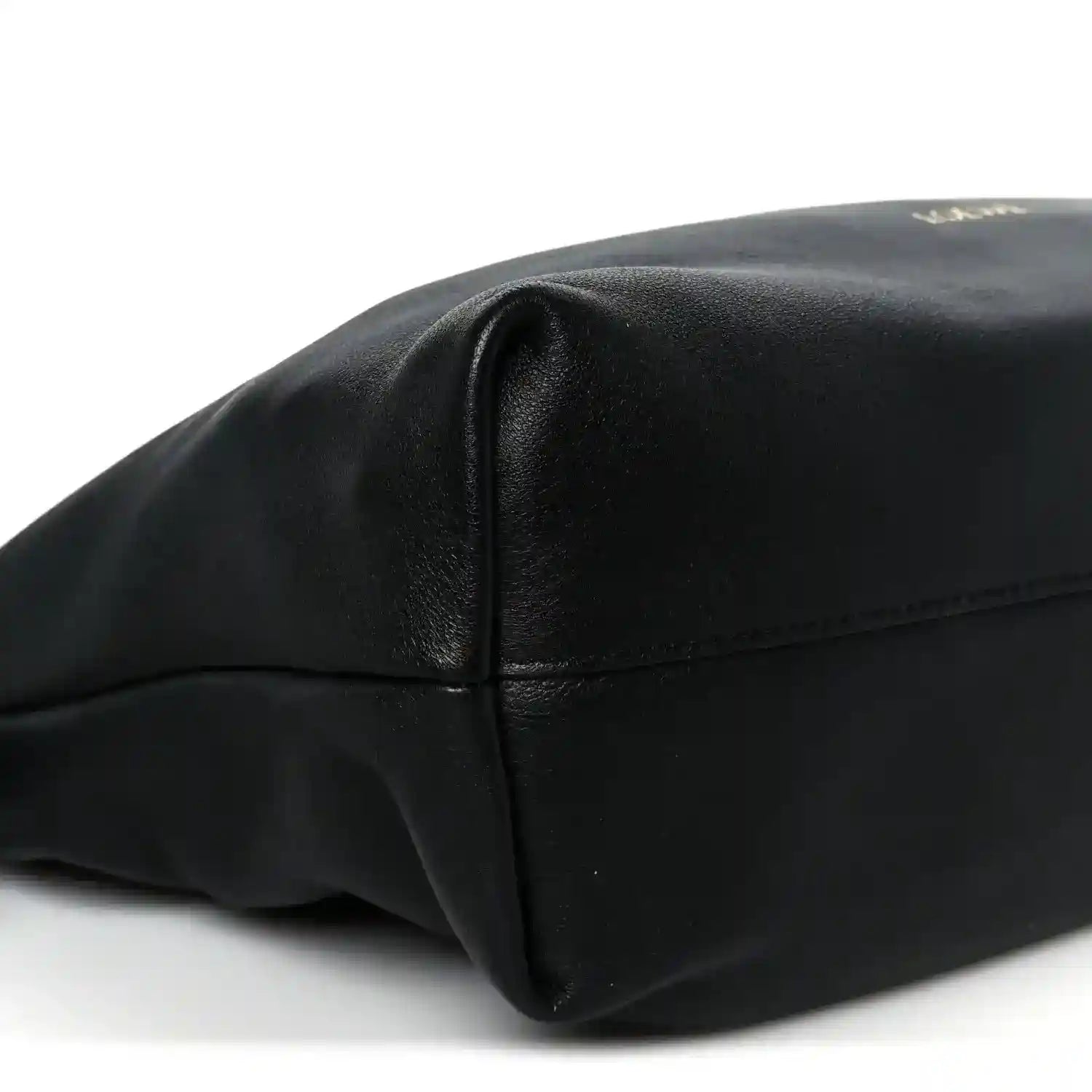 Black leather clutch end panel with stitched seam and smooth rounded corner shape.