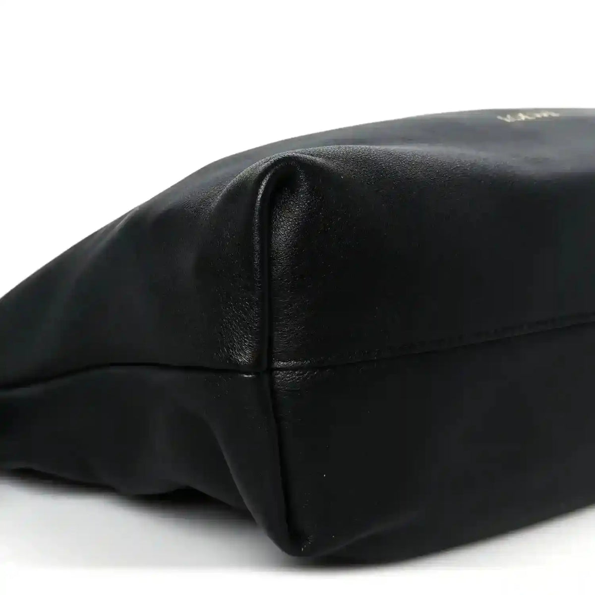 Black leather clutch end panel with stitched seam and smooth rounded corner shape.