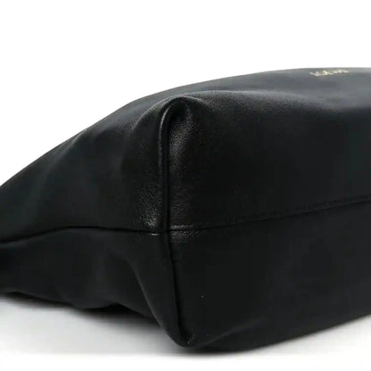 Black leather clutch end panel with stitched seam and smooth rounded corner shape.