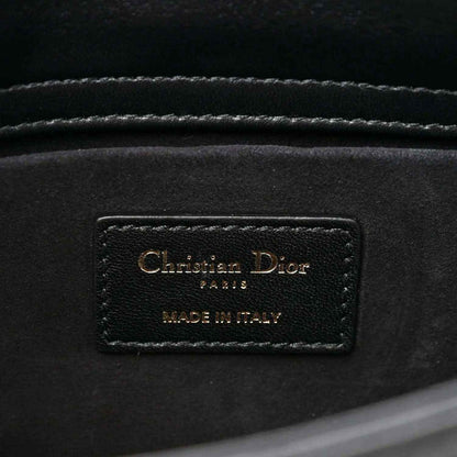 Interior brand label on black quilted handbag reading Christian Dior and MADE IN ITALY