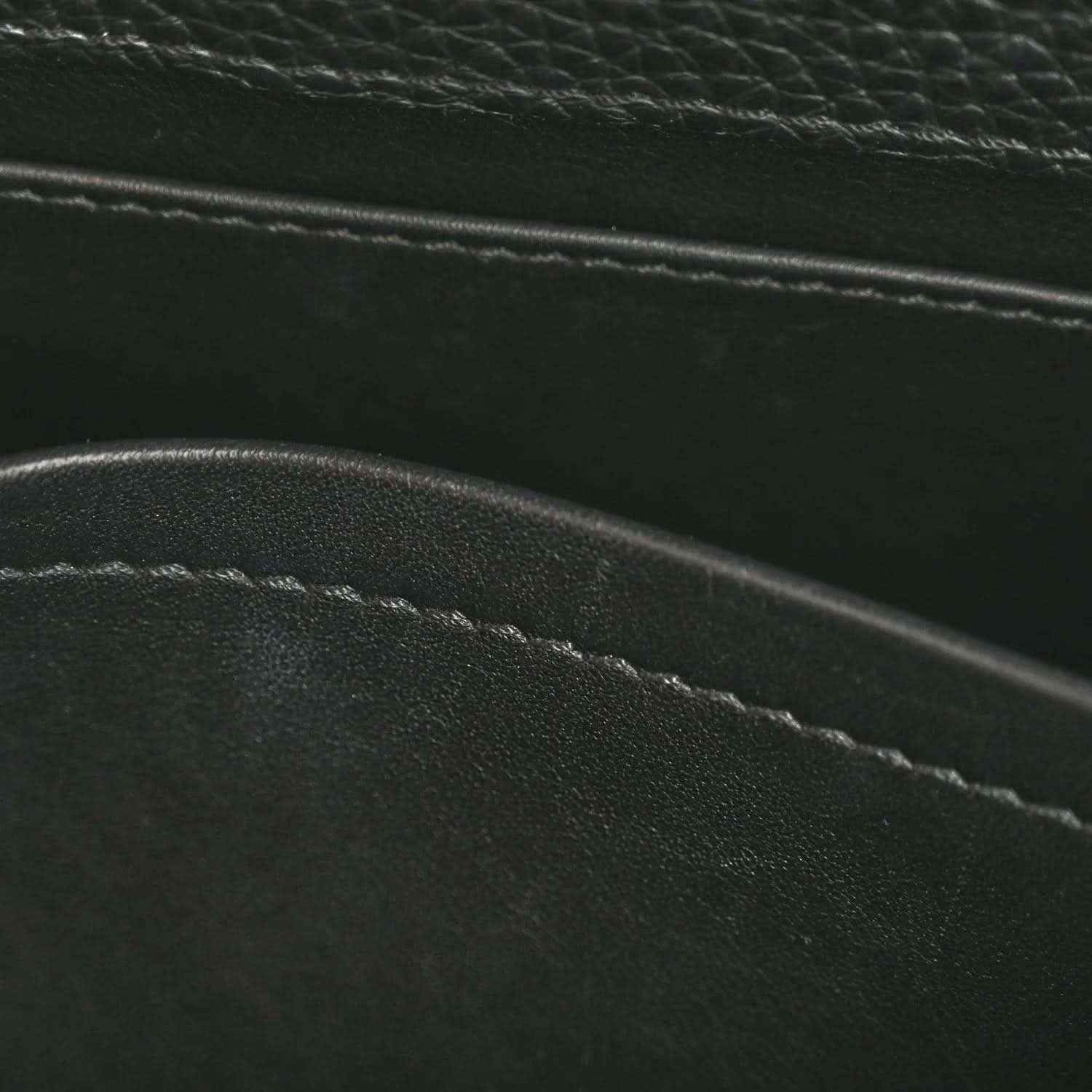 Close-up of black leather bag seam and edge stitching with pebbled texture