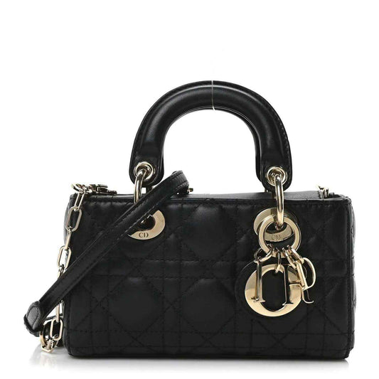Black quilted mini handbag with top handles, crossbody strap, and gold-tone rings