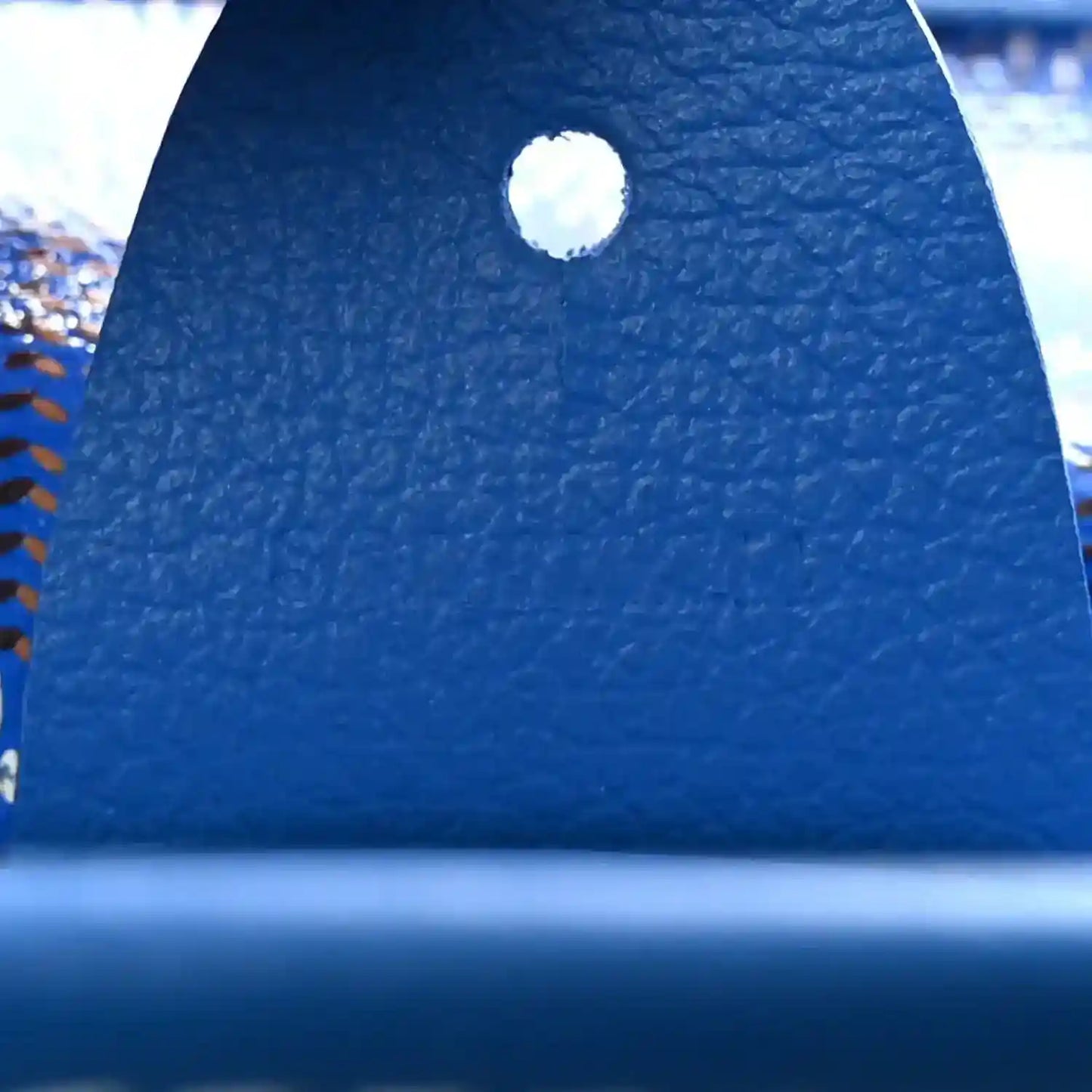 Close-up of sky blue leather grommet on tote bag handle base area