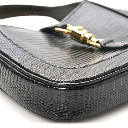 Black lizard-textured mini Jackie handbag bottom corner with curved edge trim.