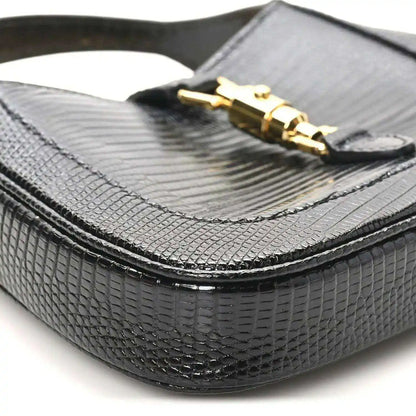 Black lizard-textured mini Jackie handbag bottom corner with curved edge trim.