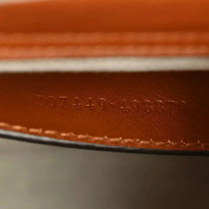Gucci mini tote bag leather base with stamped serial or style number.