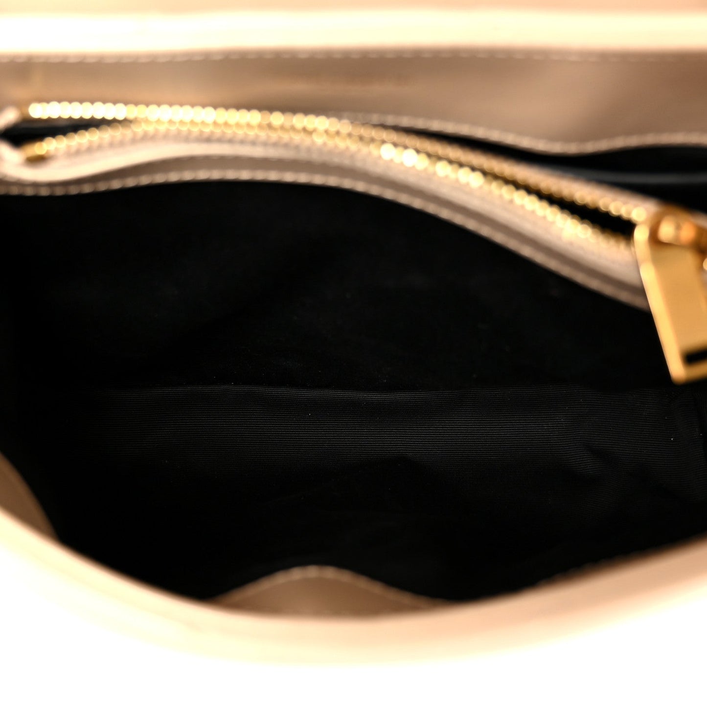 Dark beige leather satchel interior with zipper opening and gold chain trim