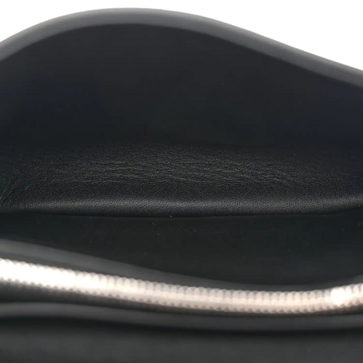 Black leather shoulder bag close-up of smooth top edge and inner lining