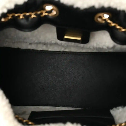 Handbag clasp close-up with gold-tone hardware and dark interior lining