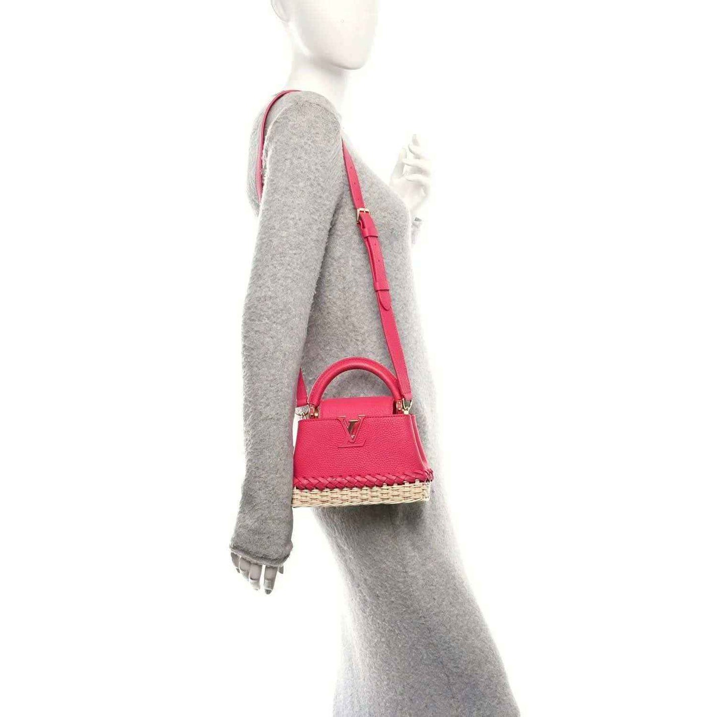 Magenta mini handbag with shoulder strap and woven rattan bottom, viewed from the side