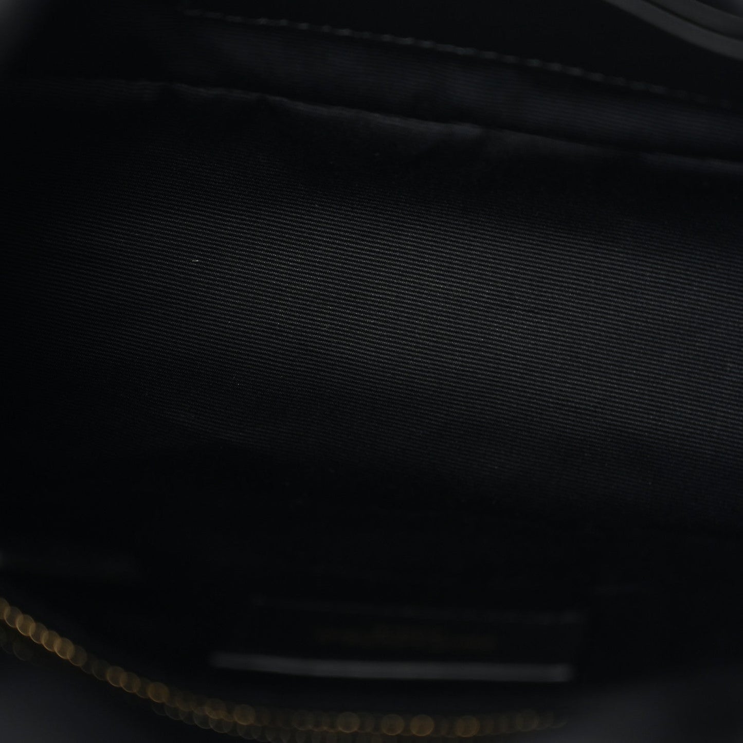 Saint Laurent satchel interior close-up with dark lining and gold-tone zipper