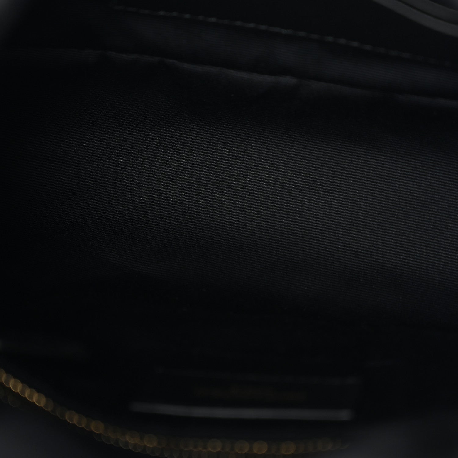 Saint Laurent satchel interior close-up with dark lining and gold-tone zipper