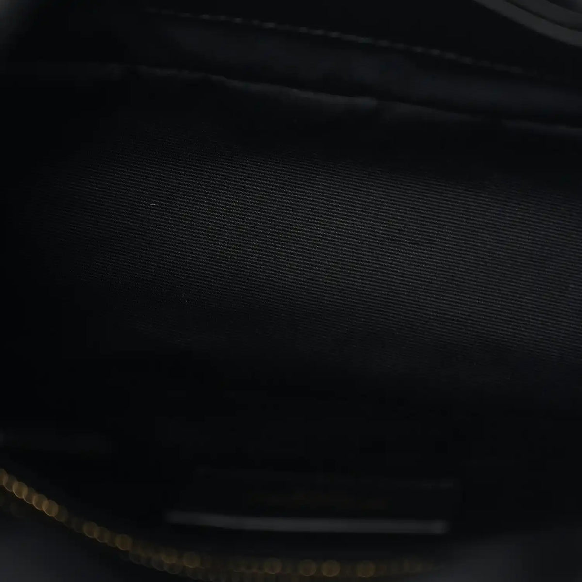 Saint Laurent satchel interior close-up with dark lining and gold-tone zipper