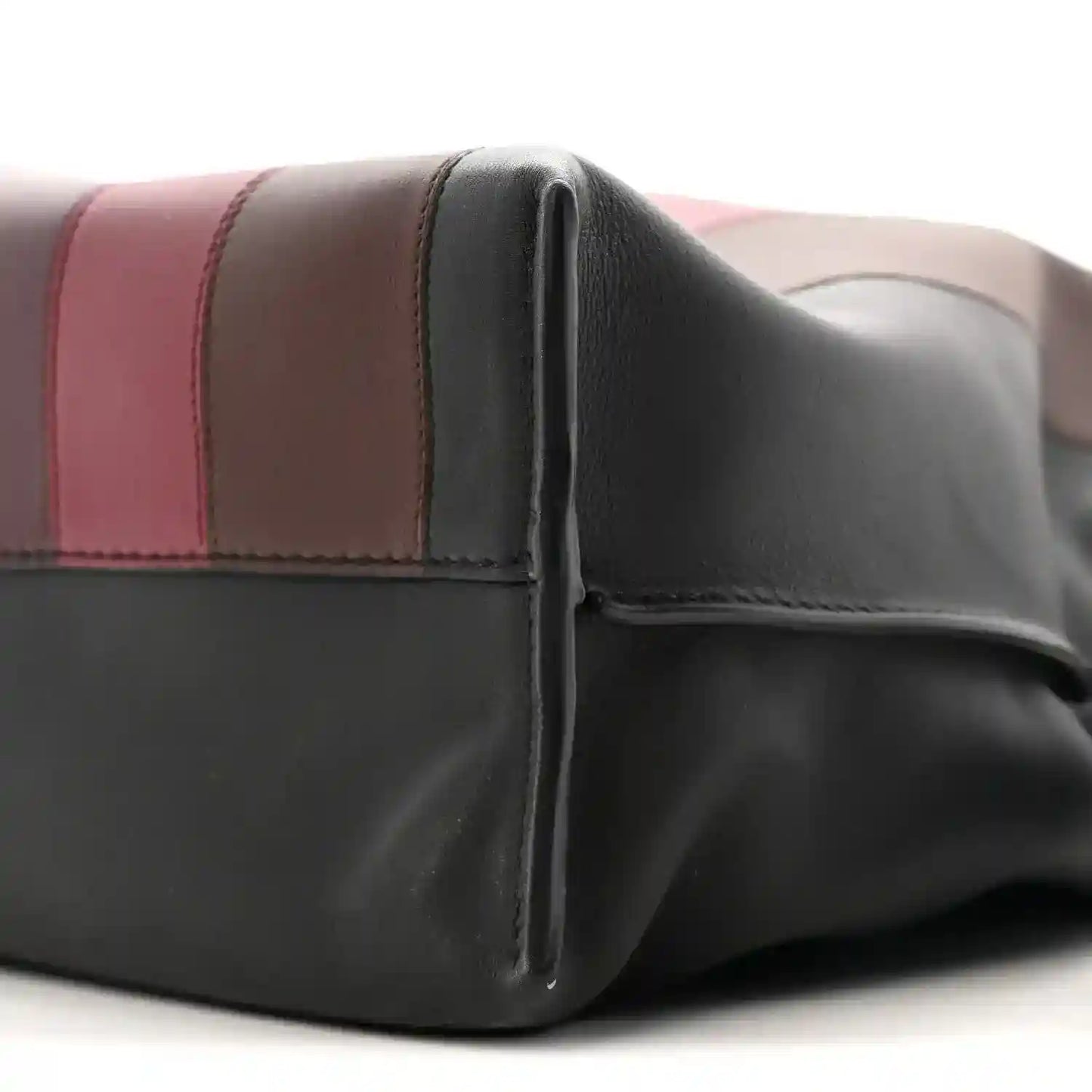 Close view of black calfskin clutch with burgundy stripe and seams