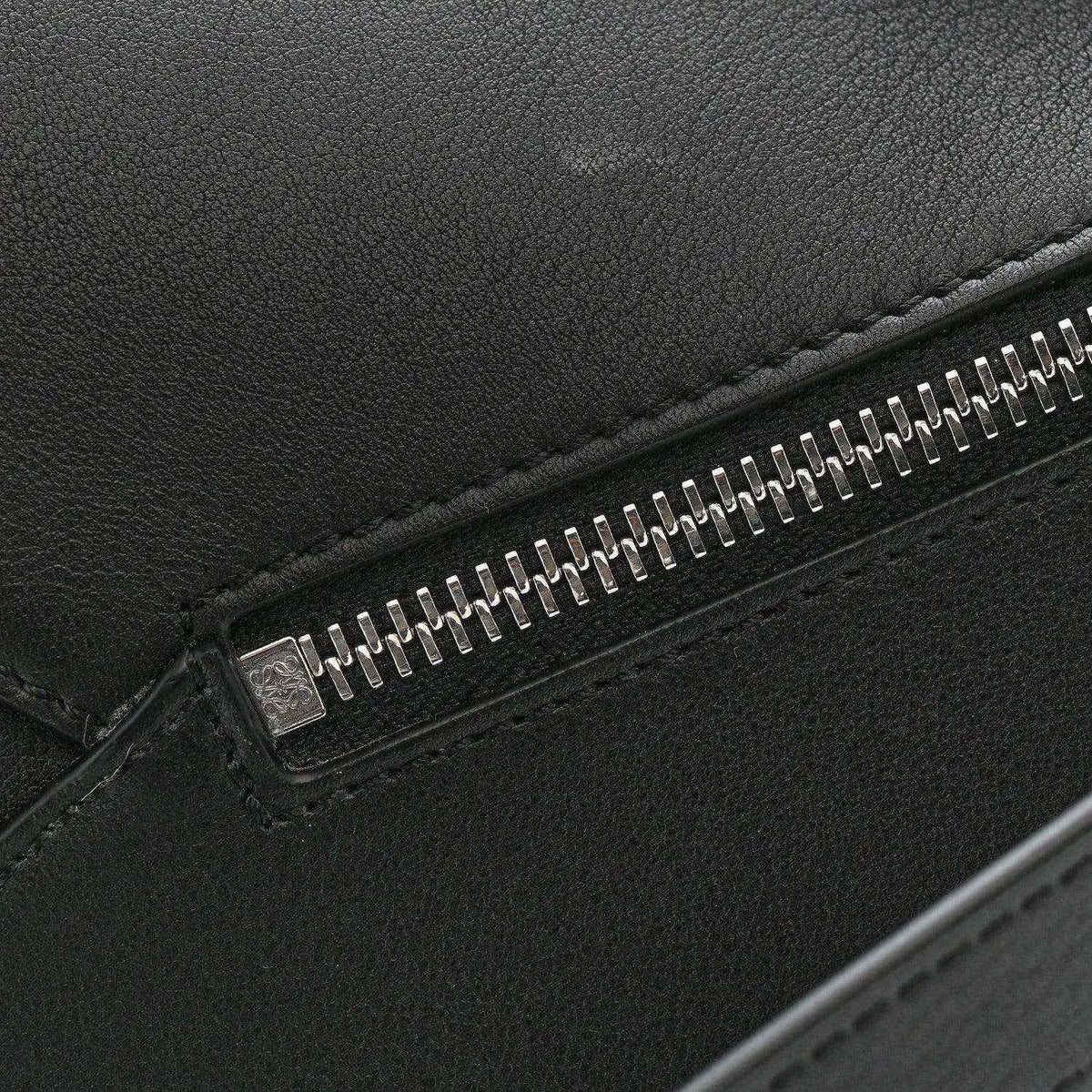 Small Puzzle Edge shoulder bag, black calfskin leather close-up of metal zipper