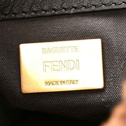Gold logo plaque reading BAGUETTE FENDI MADE IN ITALY on dark bag lining.