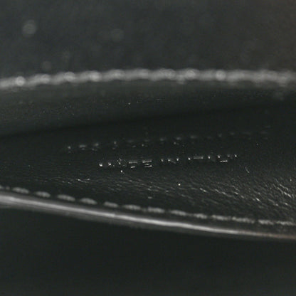 Black leather close-up showing pebbled texture and stitched trim.