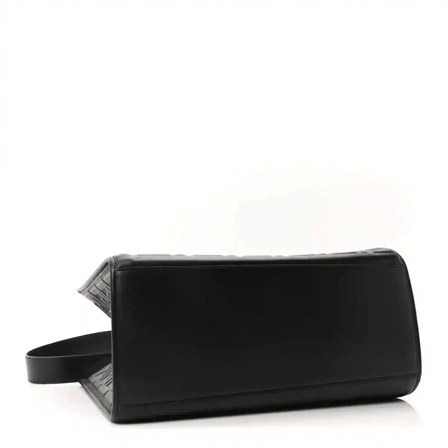 Black leather tote bag with wide side strap and structured rectangular shape