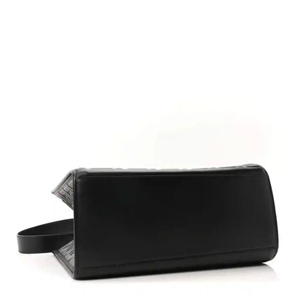 Black leather tote bag with wide side strap and structured rectangular shape