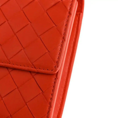 Orange intrecciato nappa clutch corner with stitched edge and structured seam