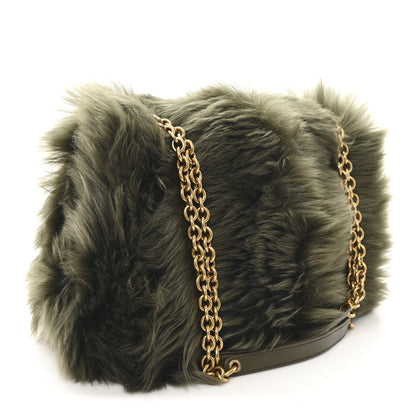 Shearling shoulder bag with dark olive fur, gold chain strap, and black base trim