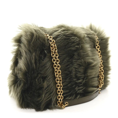 Shearling shoulder bag with dark olive fur, gold chain strap, and black base trim