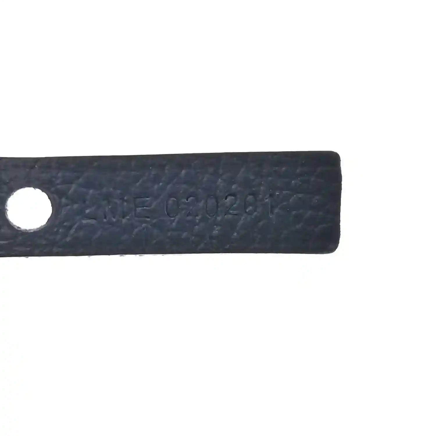 Close-up of navy leather label with stamped serial-style marking and round hole.