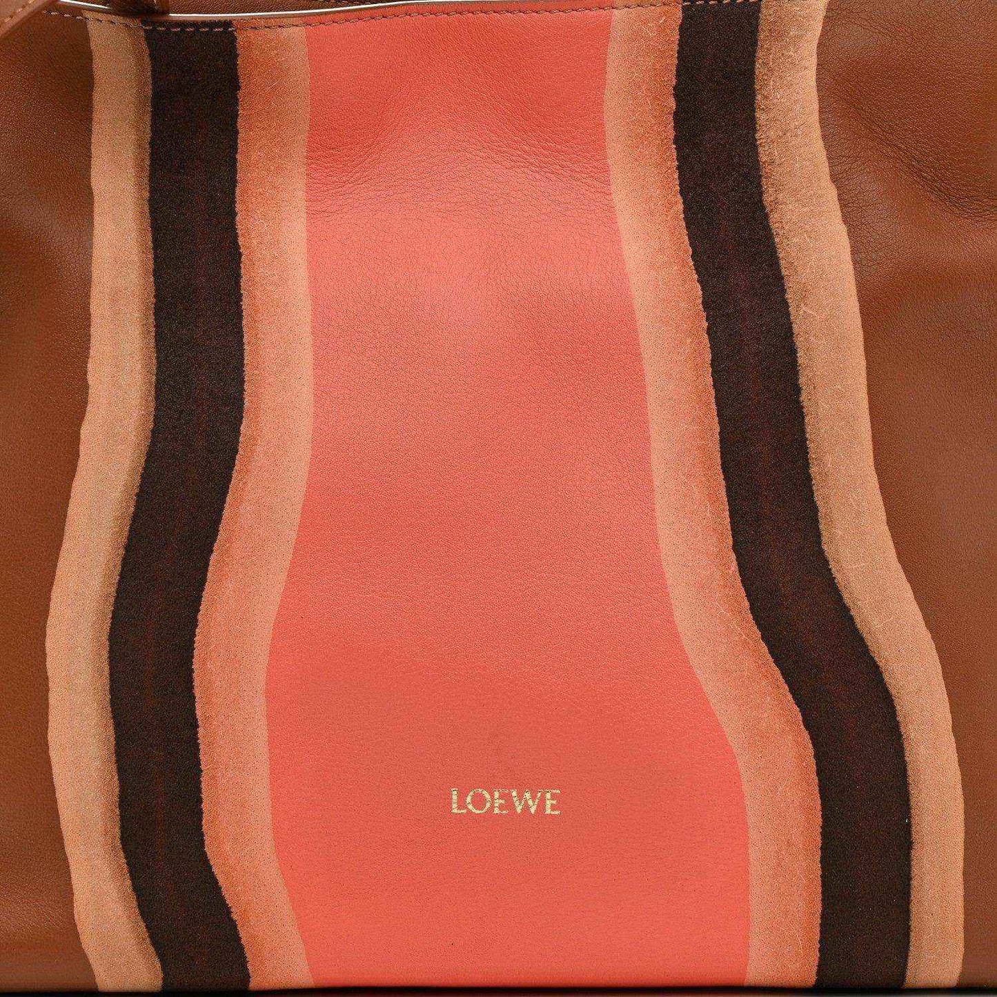 Flamenco knot clutch front panel close-up with coral leather center and striped bands