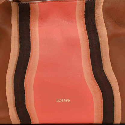 Flamenco knot clutch front panel close-up with coral leather center and striped bands