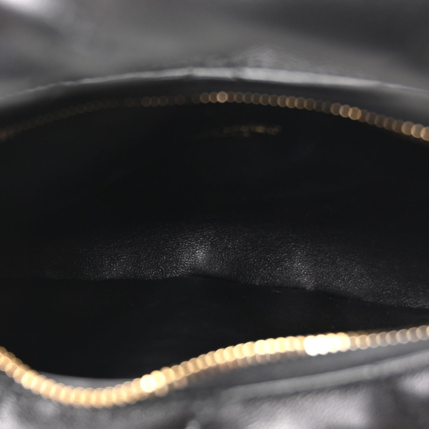 Black leather interior with gold chain trim along the top edge