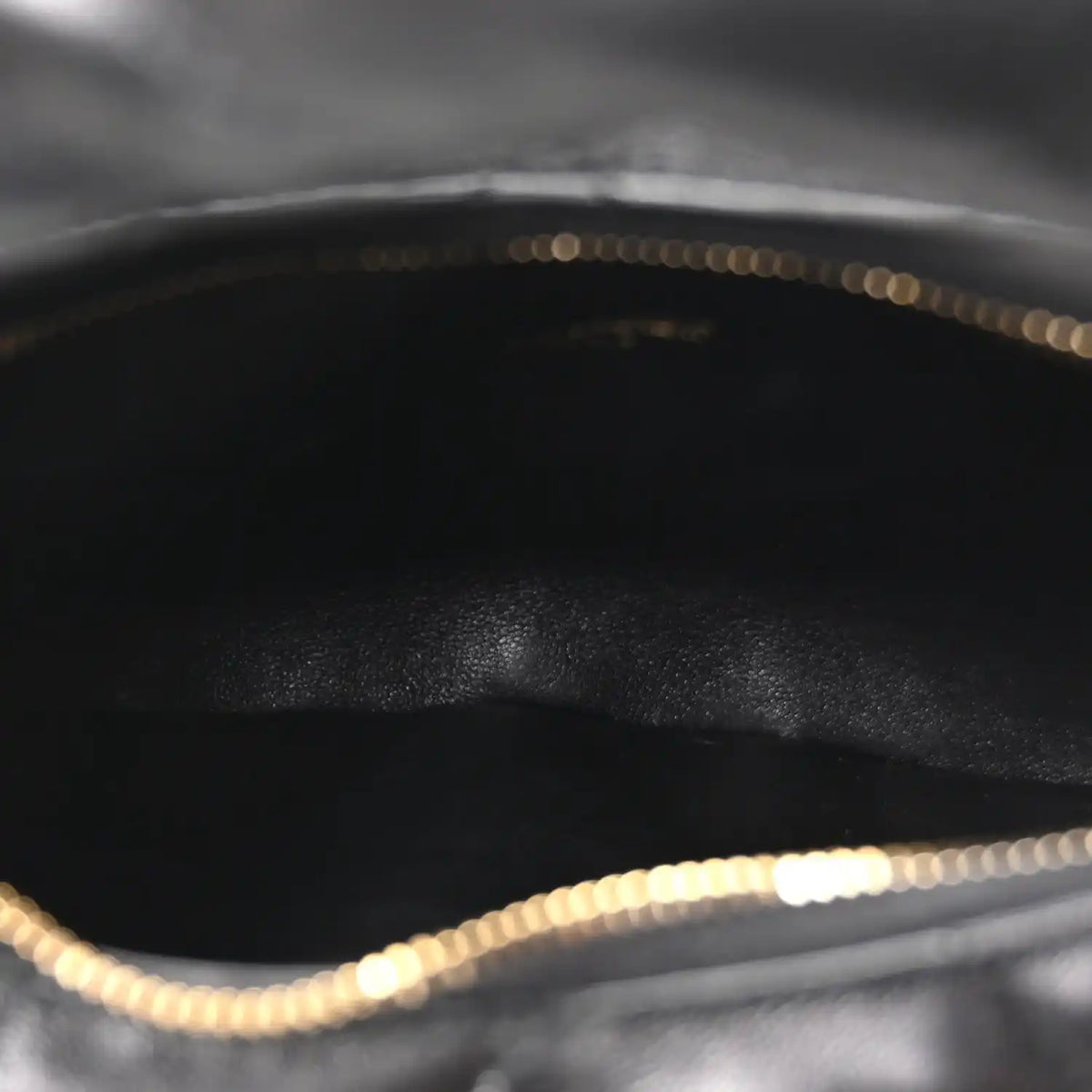 Black leather interior with gold chain trim along the top edge