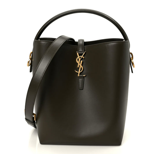 Saint Laurent shiny calfskin bucket bag in deep musk with top handle and YSL logo charm.