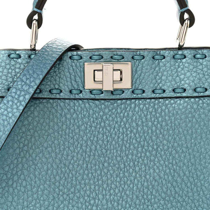 Blue pebbled leather petite satchel with front turn-lock clasp and studded trim.