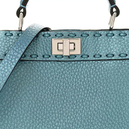 Blue pebbled leather petite satchel with front turn-lock clasp and studded trim.