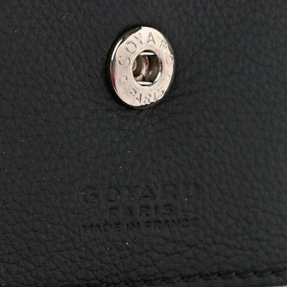 Metal brand hardware on black textured leather