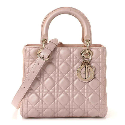 Light pink quilted handbag with top handles, detachable strap, buckle, and Dior charm