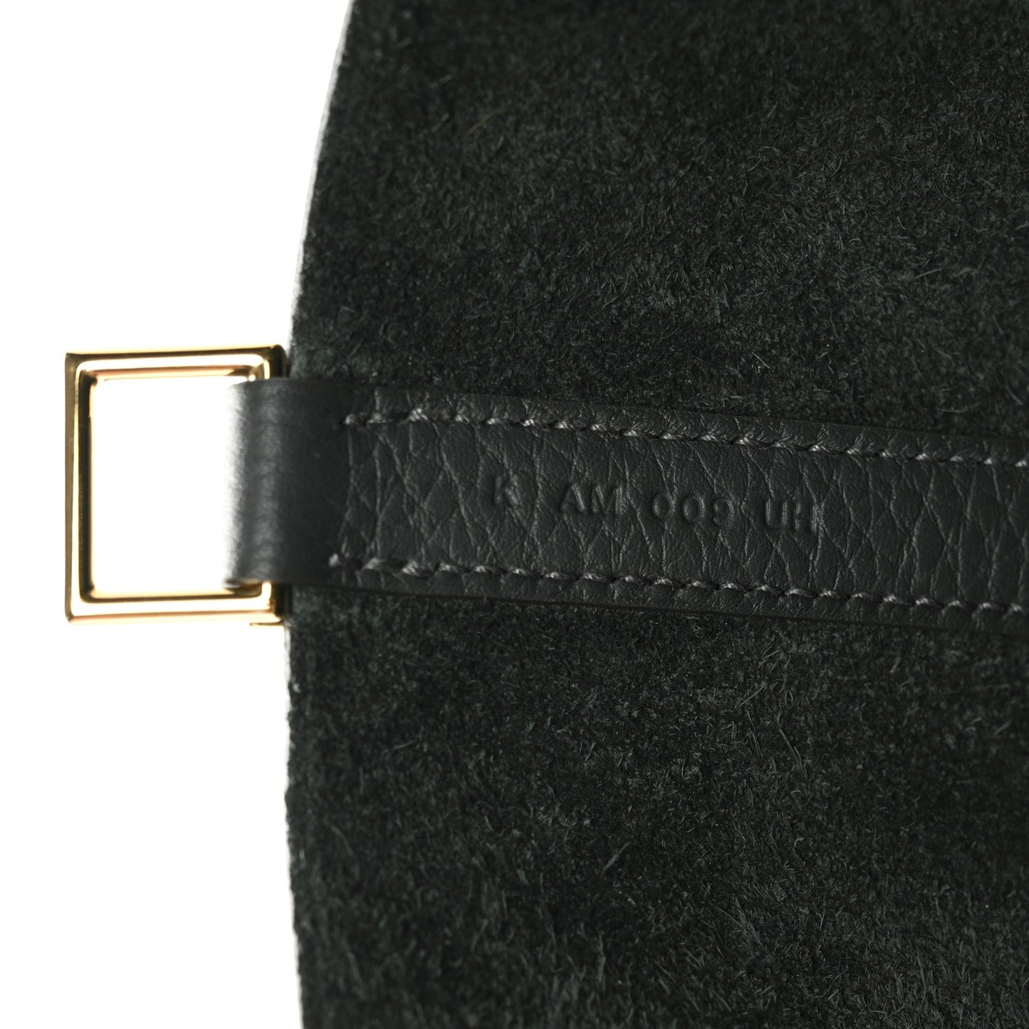 Dark green leather tab with gold-tone buckle and stitched trim on mini bag.