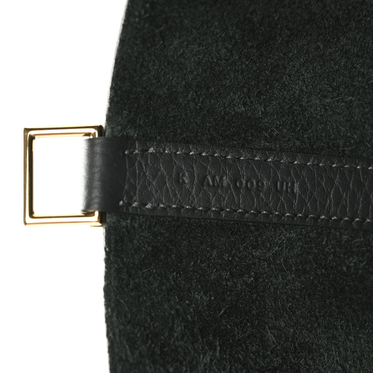 Dark green leather tab with gold-tone buckle and stitched trim on mini bag.