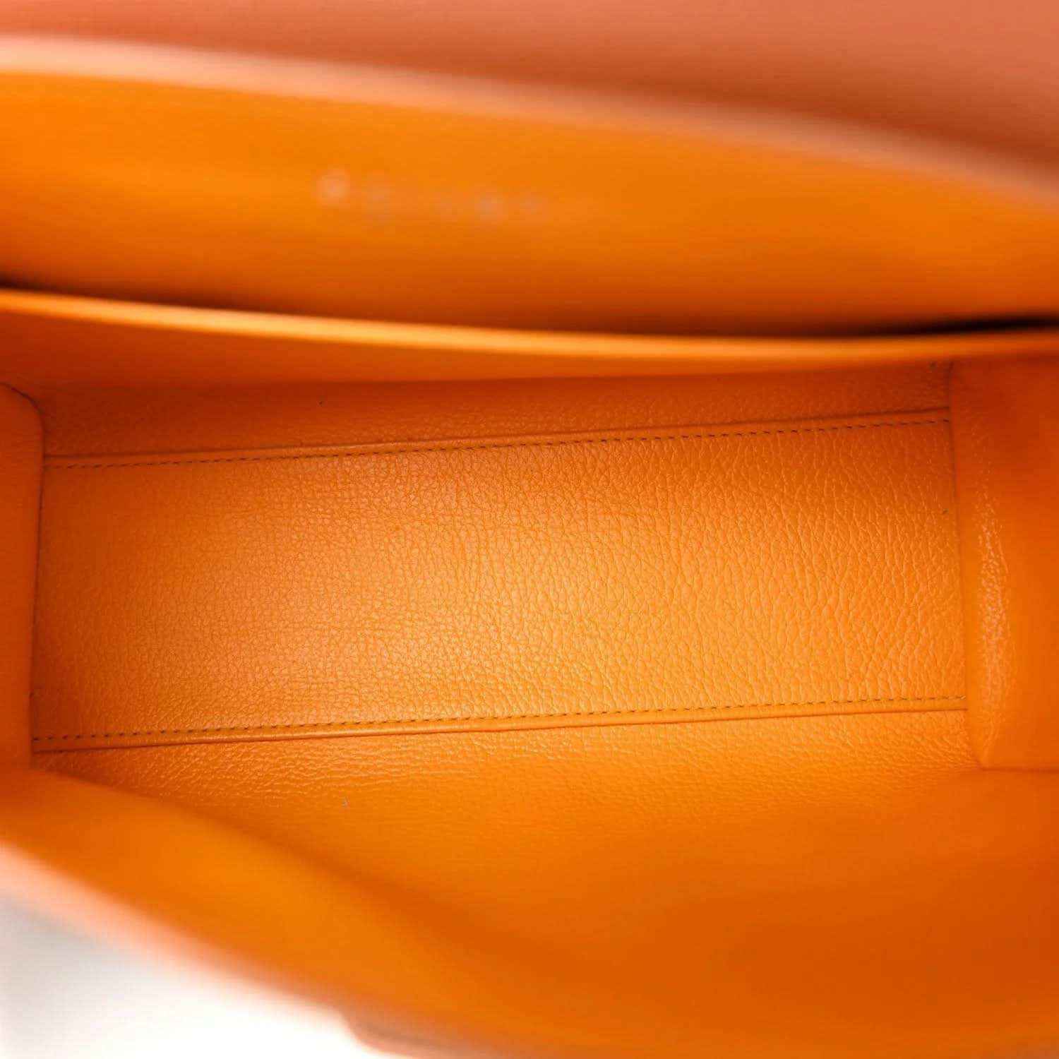 Warm orange-brown leather lining with stitched edge inside mini bag