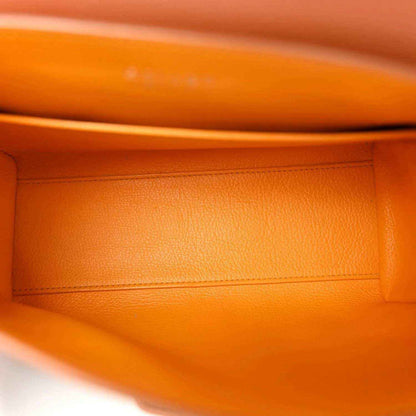 Warm orange-brown leather lining with stitched edge inside mini bag