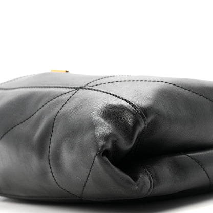 Black quilted leather drawstring bag in folded drape with stitched panels close-up