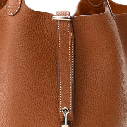 Pebbled cognac brown leather tote with gold-tone clasp and stitched vertical closure