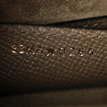 Close-up of small gold-tone text on dark green grained leather lining