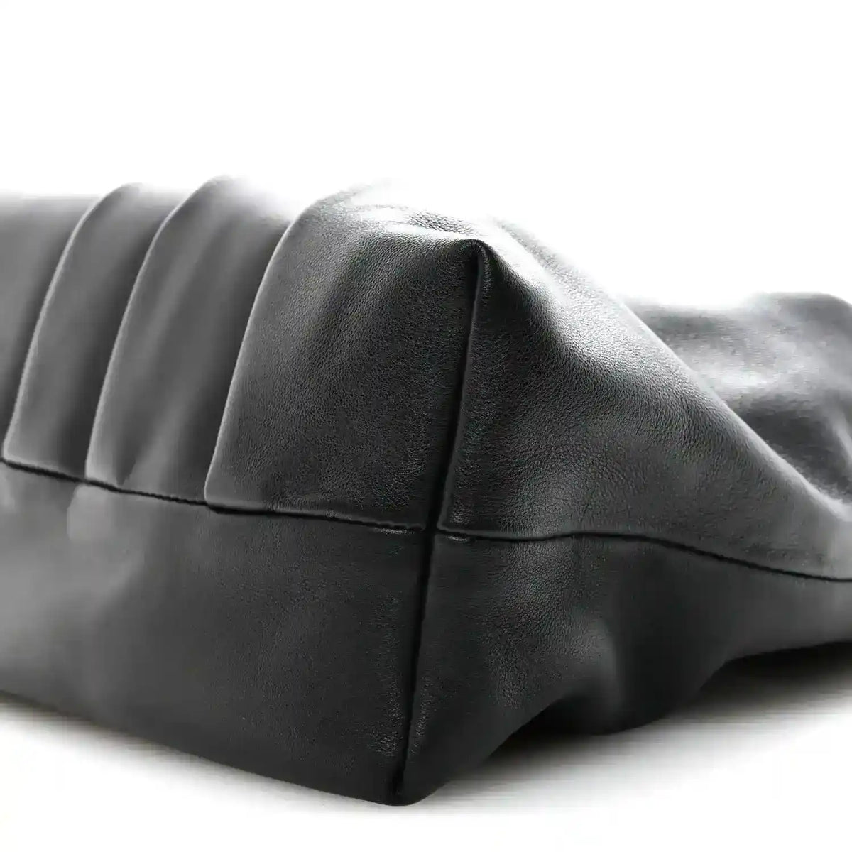 Black leather tote bag with curved side panel and stitched seams