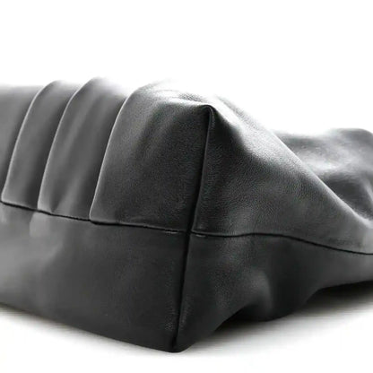 Black leather tote bag with curved side panel and stitched seams