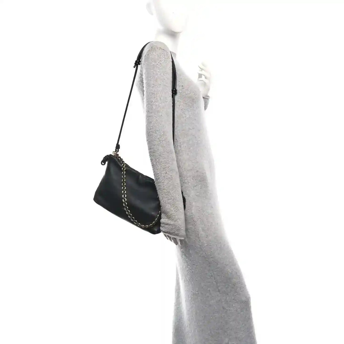 Black leather mini clutch with chain strap, shown from side on a model.