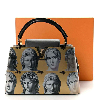 Handbag with gold face-print pattern, black handles, and gold-tone hardware