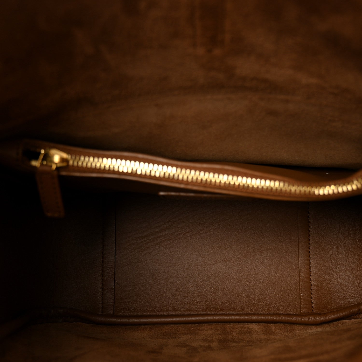 Tan leather hobo bag interior with gold-tone zipper and stitched panel