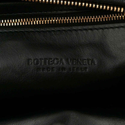 Black leather bag with engraved Bottega Veneta logo near zipper